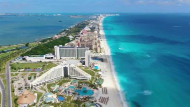Karayip beyazı, bozulmamış kumlu kumsal hava aracı manzaralı. Meksika 'nın Quintana Roo eyaletindeki Yucatn Yarımadası' ndaki Cancun Körfezi üzerinde uçuyor. Paradisiacal plajlarda turist oteli kompleksi. Beyaz kumsallar, şemsiyeler ve güneşlenen turistler..