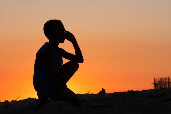 Junge am Strand bei Sonnenuntergang — Stockfoto