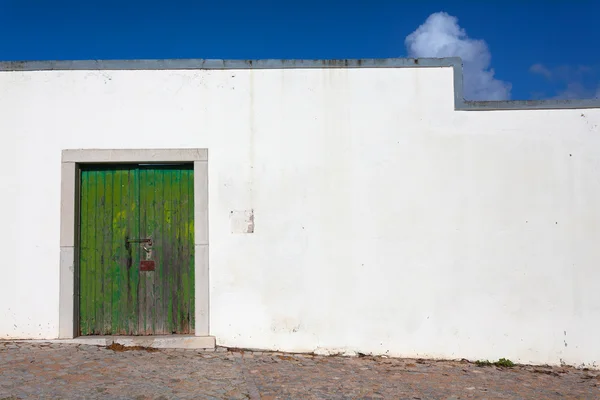 Zielone drzwi na białej ścianie — Zdjęcie stockowe