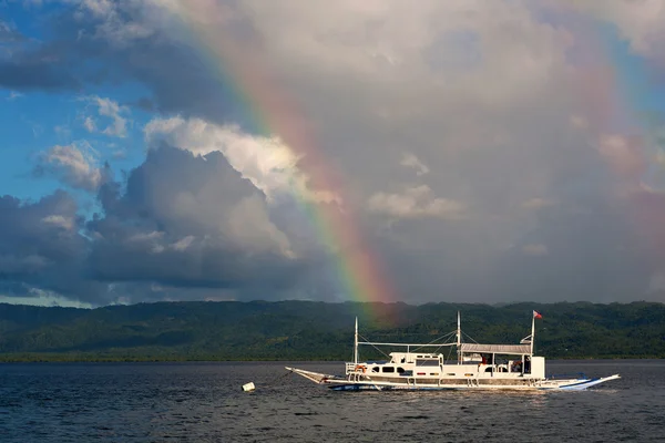 Boot im Meer vor dem Hintergrund des Regenbogens — Stockfoto