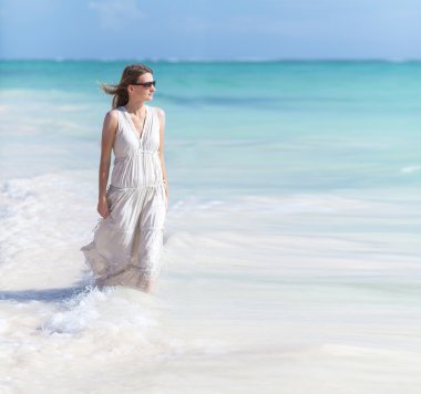 Sahilde beyaz elbiseli genç kız.