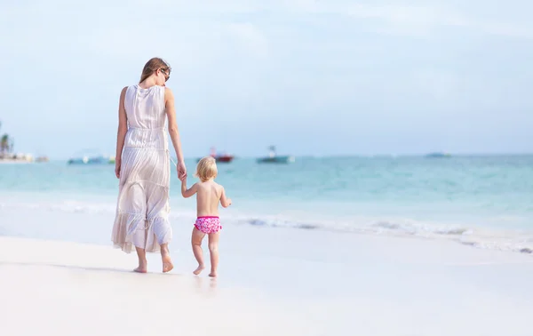 Mor och dotter promenerar på stranden — Stockfoto