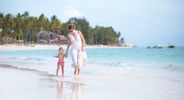 Mère et petite fille marchant sur la plage — Photo