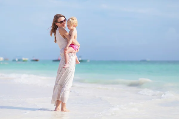 Moeder en kleine dochter wandelen op het strand — Stockfoto