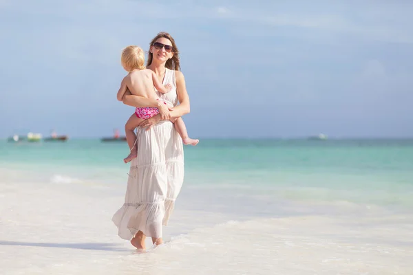 Mor och dotter promenerar på stranden — Stockfoto