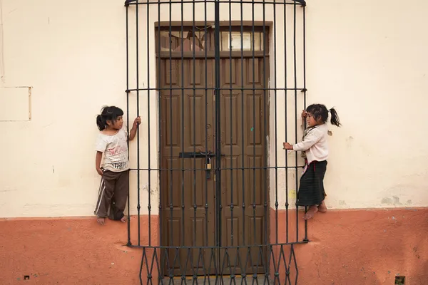 Maya kafes ile kapının yanında iki kız — Stok fotoğraf