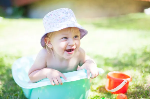 Dziewczynka gry z wodą na trawie — Zdjęcie stockowe