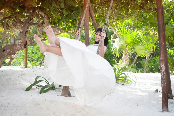 The bride shakes on a swing on a beach — Stock Photo, Image