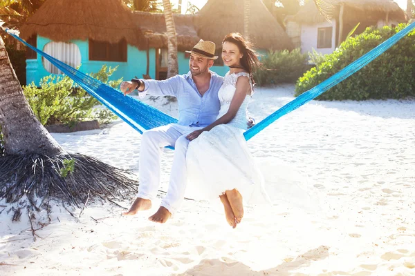 Paar zitten in een hangmat op het strand — Stockfoto