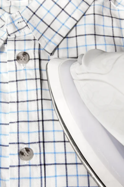 Electric iron and checkered shirt — Stock Photo, Image
