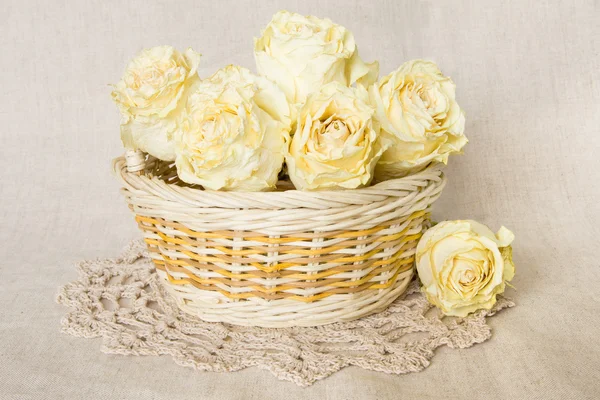 Dried roses in basket with doily — Stock Photo, Image