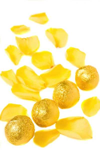 Конфеты и желтые лепестки — стоковое фото