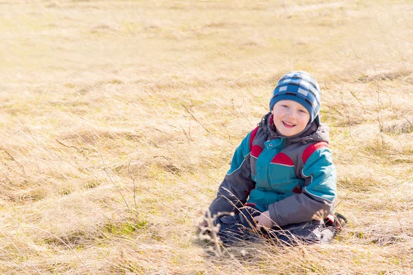 Child on dry grass (field) — Stock Photo, Image