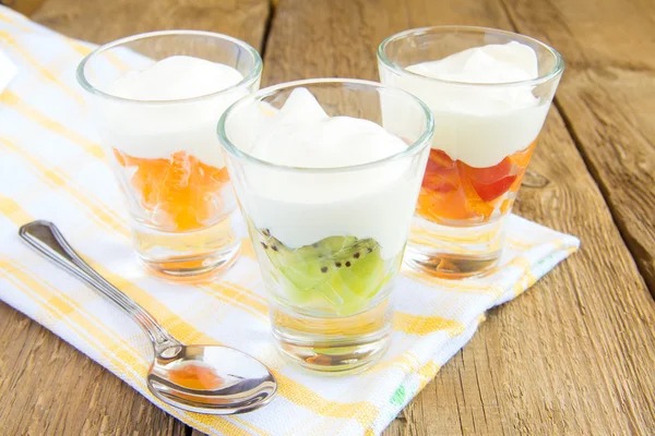 Свежий йогурт с фруктами и ложкой — стоковое фото