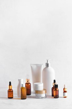 Beyaz masadaki cilt bakımı ürünleri, kozmetik şişelerinin çeşitliliği, sağlıklı kozmetoloji, spa tedavisi konsepti, kopyalama alanı.