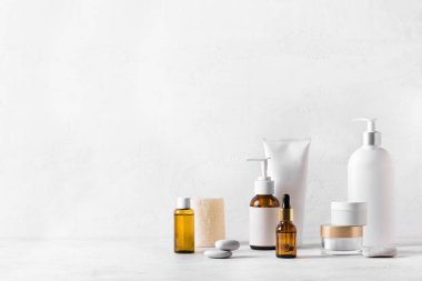 Beyaz masadaki cilt bakımı ürünleri, kozmetik şişelerinin çeşitliliği, sağlıklı kozmetoloji, spa tedavisi konsepti, kopyalama alanı.