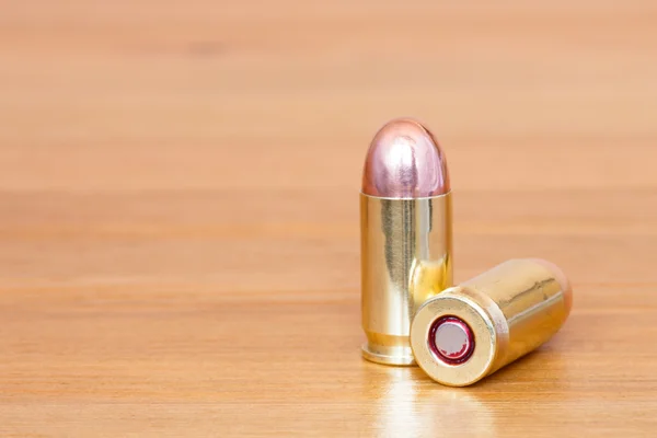 9 mm or .357 bullet on wooden background — Stock Photo, Image