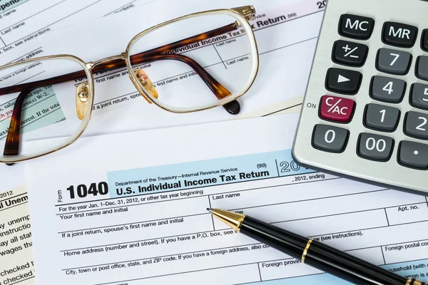 Formulario de impuestos con pluma, calculadora, y el concepto de impuestos gafas —  Fotos de Stock