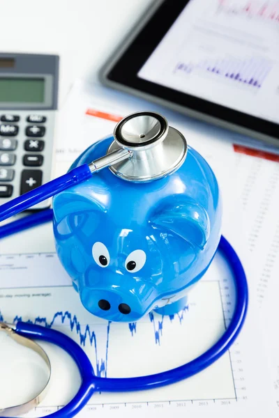 Stethoskop und Sparschwein für das Konzept des finanziellen Gesundheitschecks — Stockfoto