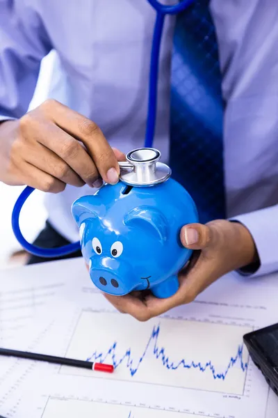 Finansal sağlığı için kumbara ile işadamı kullanım stetoskop