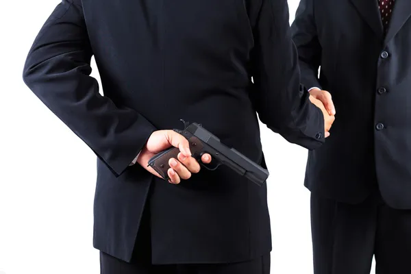 Businessman hiding gun while handshaking concpet for dishonesty — Stock Photo, Image