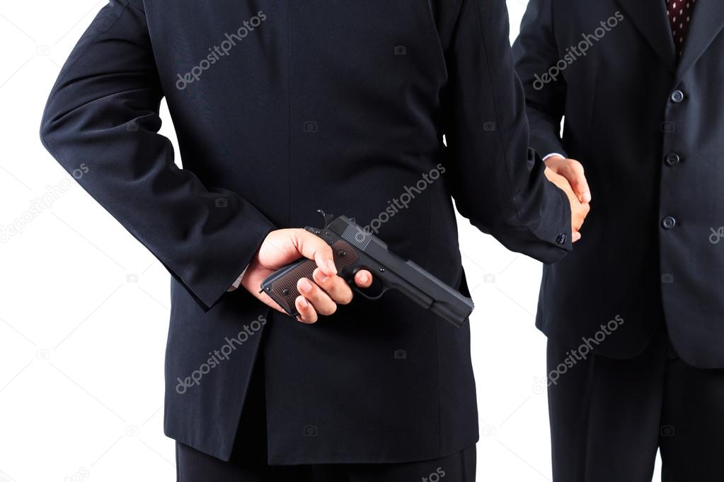 Businessman hiding gun while handshaking concpet for dishonesty