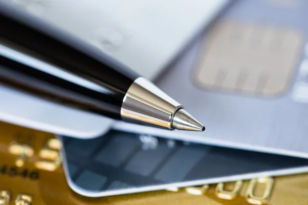 Pen on credit stack of cards low dept of field — Stock Photo, Image