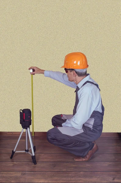 Foreman bir lazer düzeyde kalitesini kontrol eder.