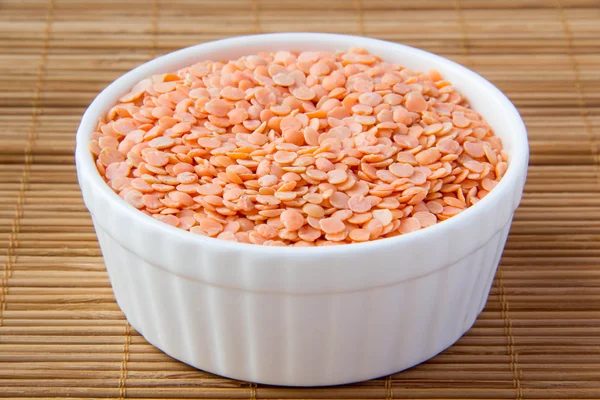 Red lentils in white ceramic cup — Stock Photo, Image