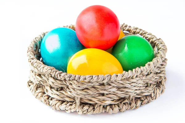 Colored painted eggs in a basket — Stock Photo, Image