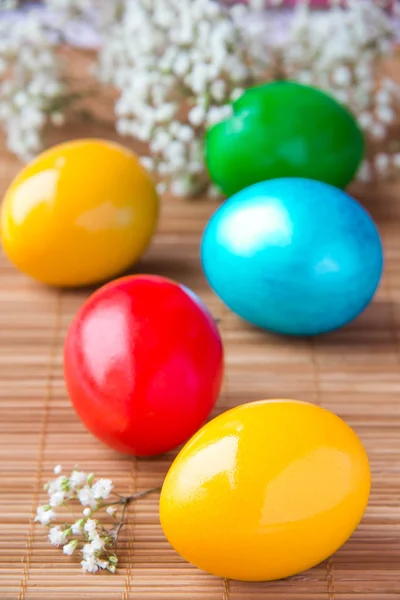 Colored painted eggs on bamboo table — Stock Photo, Image