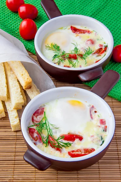Baked eggs with cheese, tomatoes and croutons — Stock Photo, Image