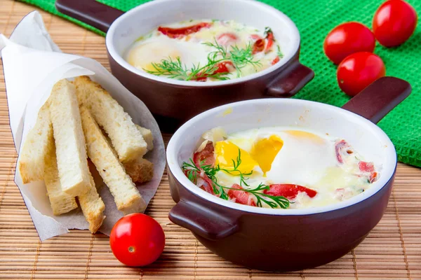 Baked eggs with cheese, tomatoes and croutons — Stock Photo, Image