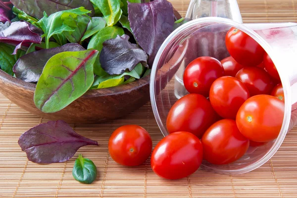 Tomates cherry derramados y ensalada — Foto de Stock