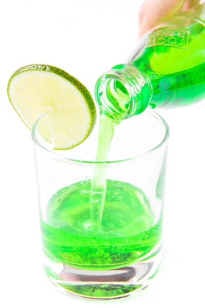 Zielony napój przelewa się z butelki do szkła — Zdjęcie stockowe