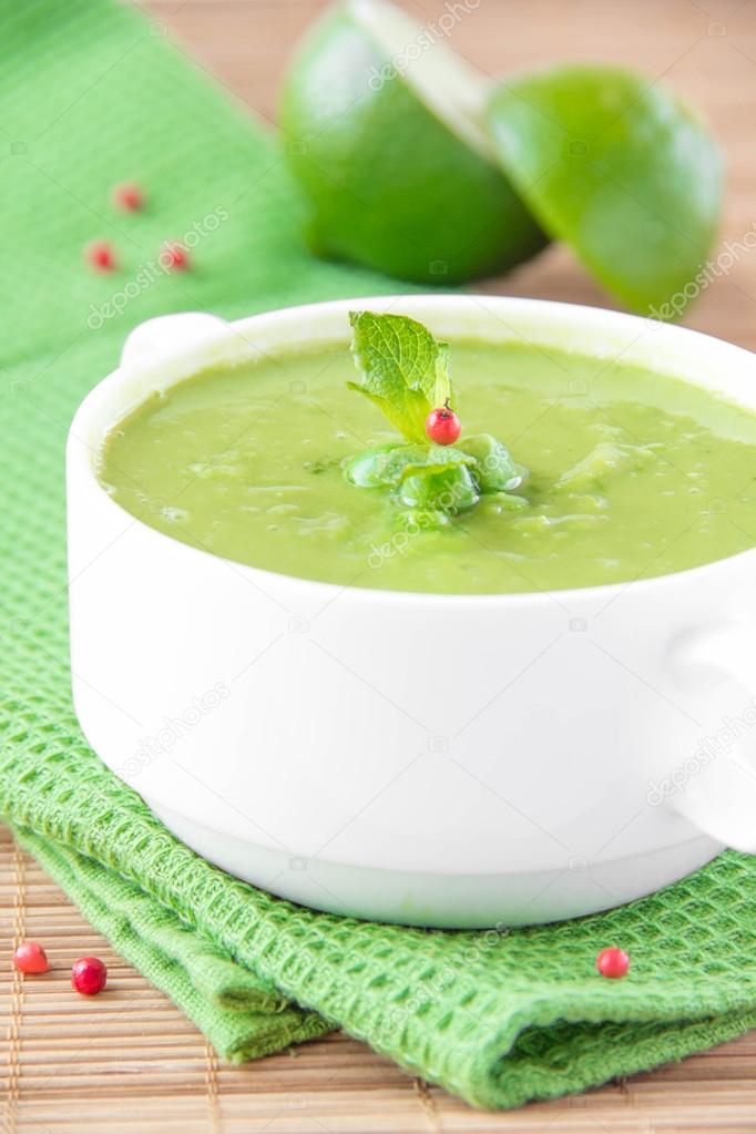 Velvety cream soup from a gentle green peas in white ceramic cup