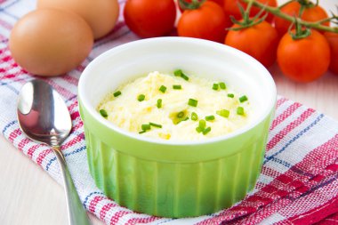 Whipped steam eggs in a cup with green onions for breakfast clipart