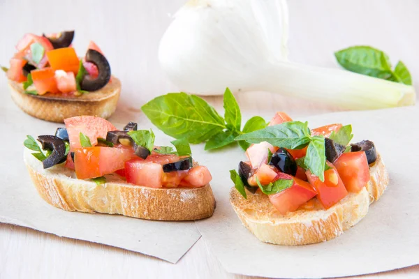 Klasszikus olasz előétel bruschetta paradicsommal, bazsalikommal, fekete — Stock Fotó