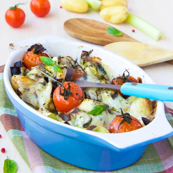 Mélange de légumes dans un bol bleu cuit au four avec du fromage et b — Photo