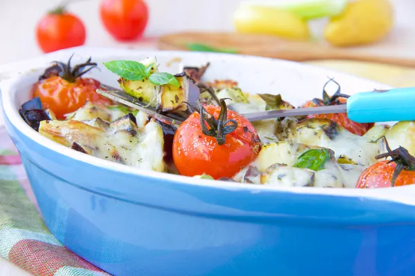 Mélange de légumes dans un bol bleu cuit au four avec du fromage et b — Photo