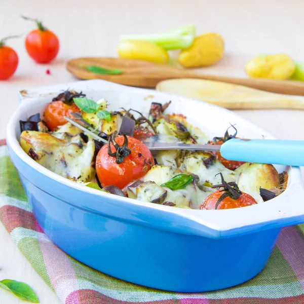 Verdura mista in ciotola blu cotta in forno con formaggio e b — Foto Stock