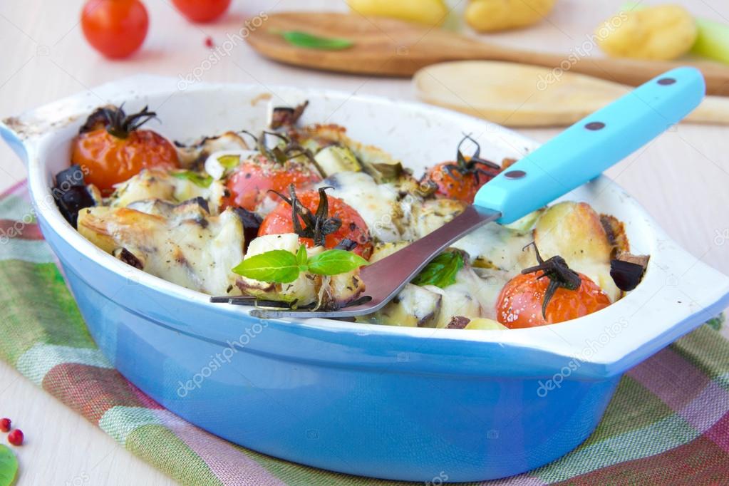 Mixed vegetable in blue bowl baked in the oven with cheese and b