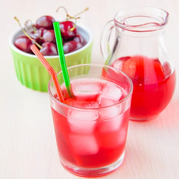 Delicious sweet berry lemonade of cherry in glass and carafe — Stock Photo, Image