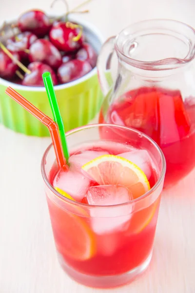 Delicious sweet berry juice of cherry in glass and carafe — Stock Photo, Image