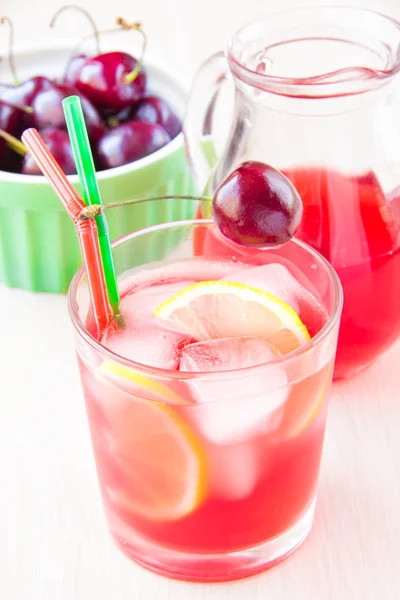 Delicious sweet berry juice of cherry in glass and carafe — Stock Photo, Image