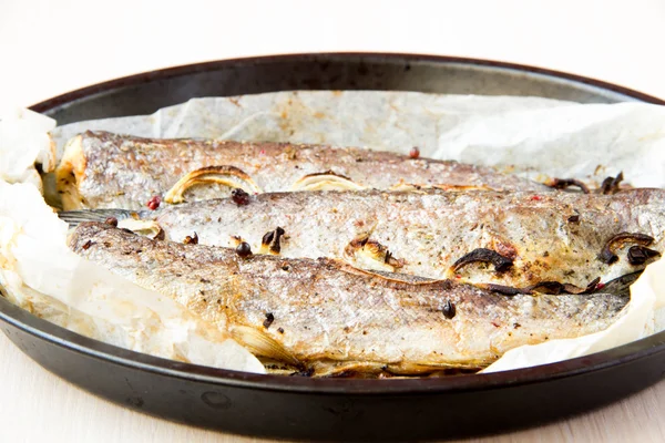 Tasty dish is baked in a pan rainbow trout with onions and spice — Stock Photo, Image