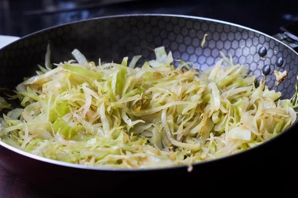 Fresh cabbage fried on frying pan, tasty dish — Stock Photo, Image