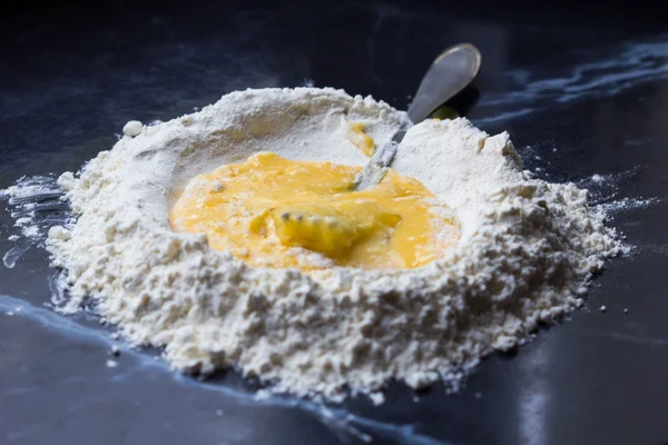 Pile of flour with cavity and eggs for cooking dough, Italian pa — Stock Photo, Image