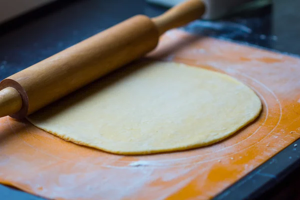 Pâte fine pour pâtes ou pizza sur table avec rouleau à pâtisserie — Photo