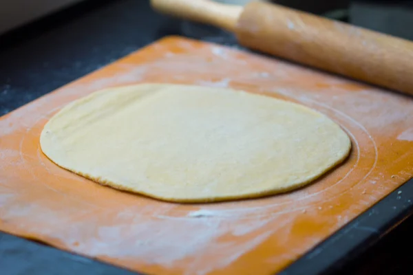 Dünner Teig für Pasta oder Pizza auf dem Tisch mit Nudelholz — Stockfoto